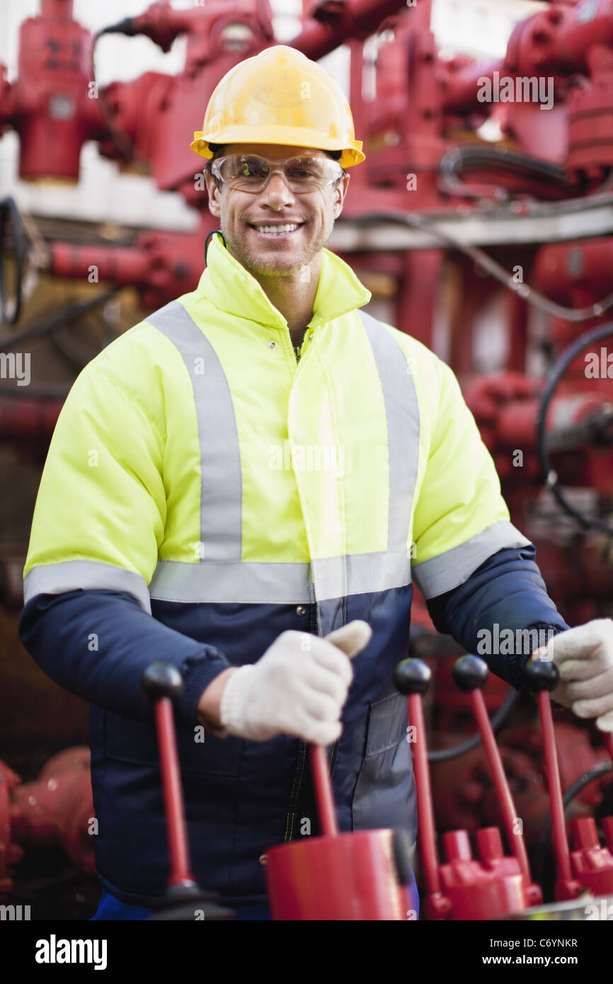 Worker operating machinery on oil rig Stock Photo