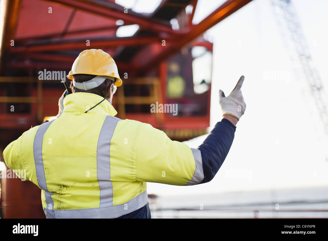 Worker using walkie talkie on oil rig Stock Photo