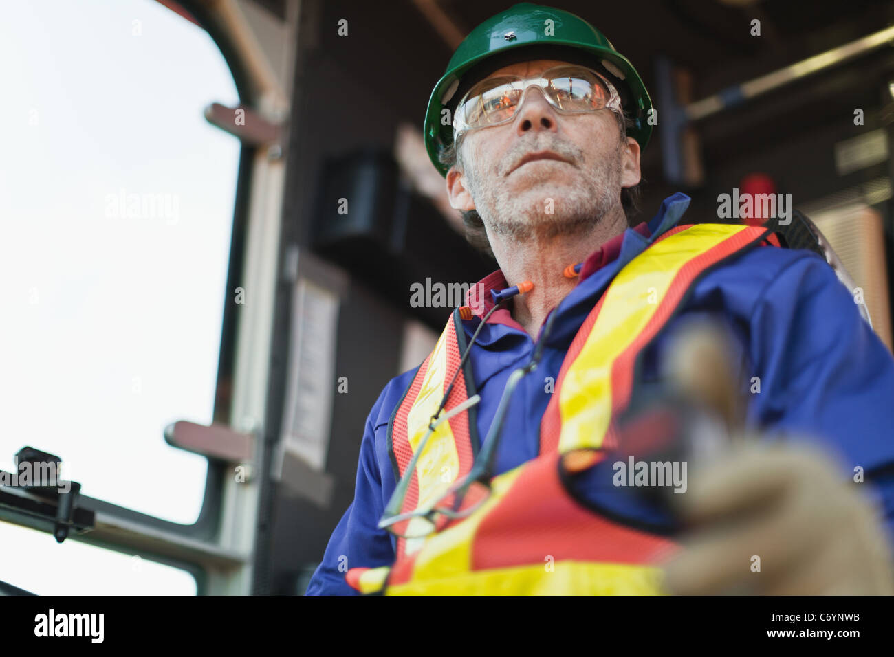 Worker operating machinery on oil rig Stock Photo