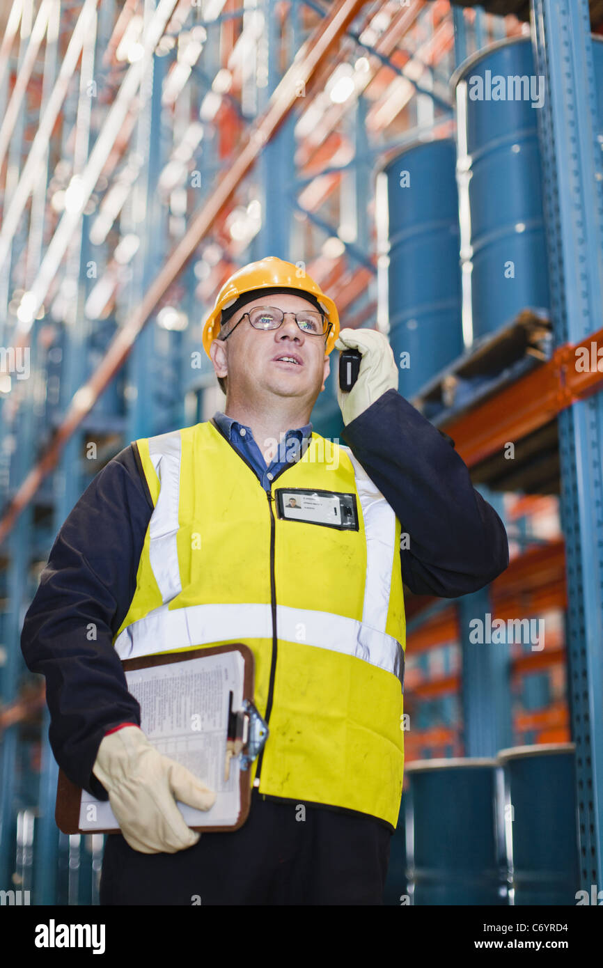 Worker using cell phone in warehouse Stock Photo Alamy