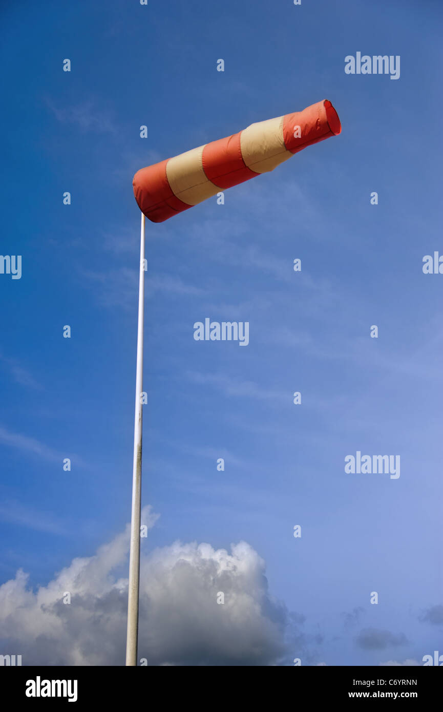 A striped weather vane at the airfield against blue sky Stock Photo