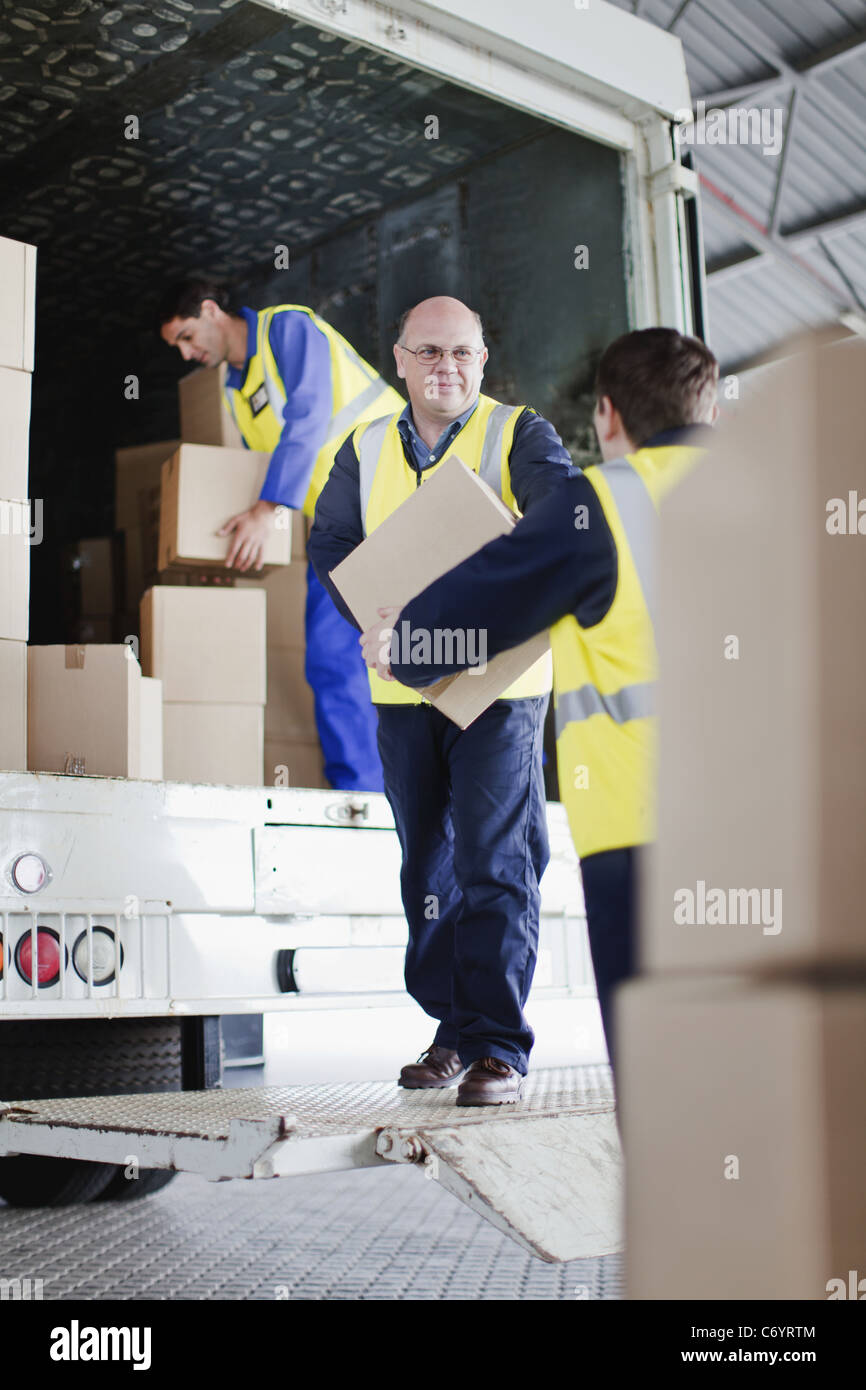 Workers unloading boxes from truck Stock Photo