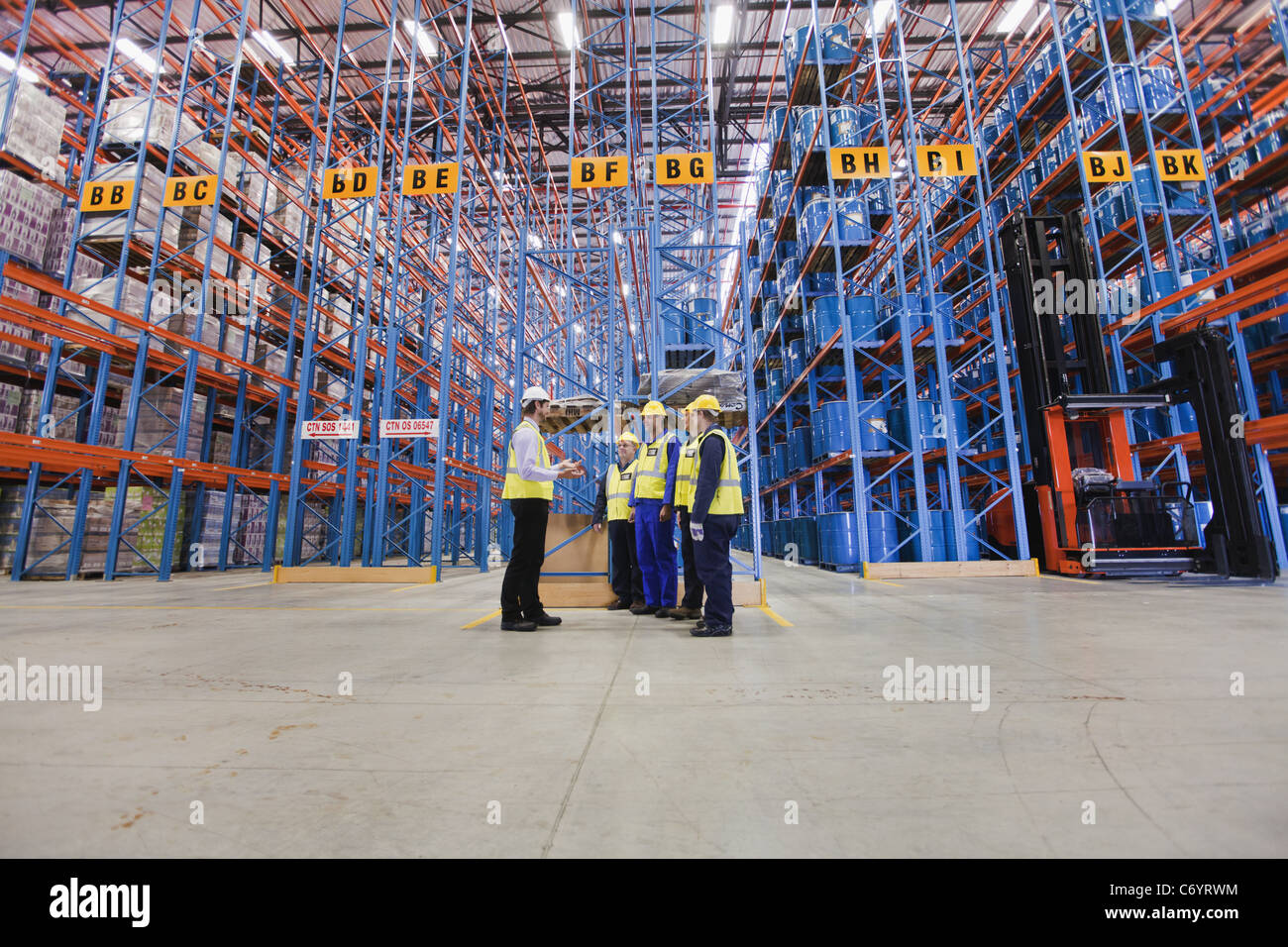 Workers talking in warehouse Stock Photo - Alamy