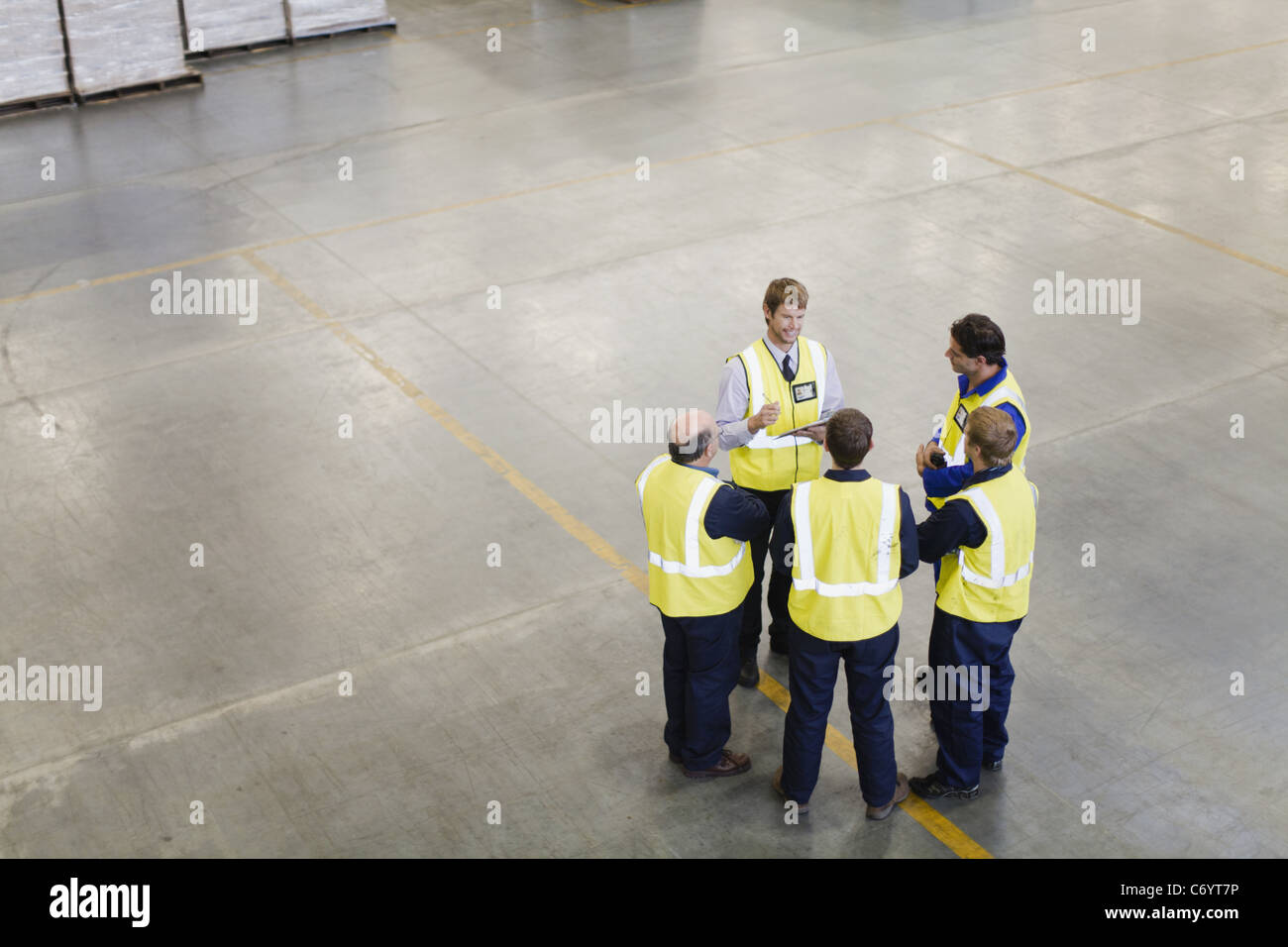 Workers talking in warehouse Stock Photo - Alamy