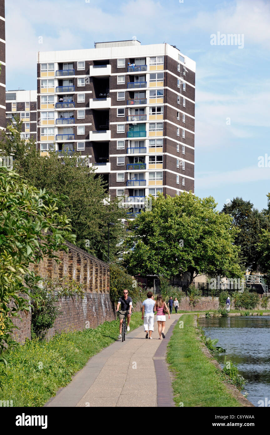 Cyclist and walkers on towpath with flats behind Regent's Canal Hackney London England UK Stock Photo