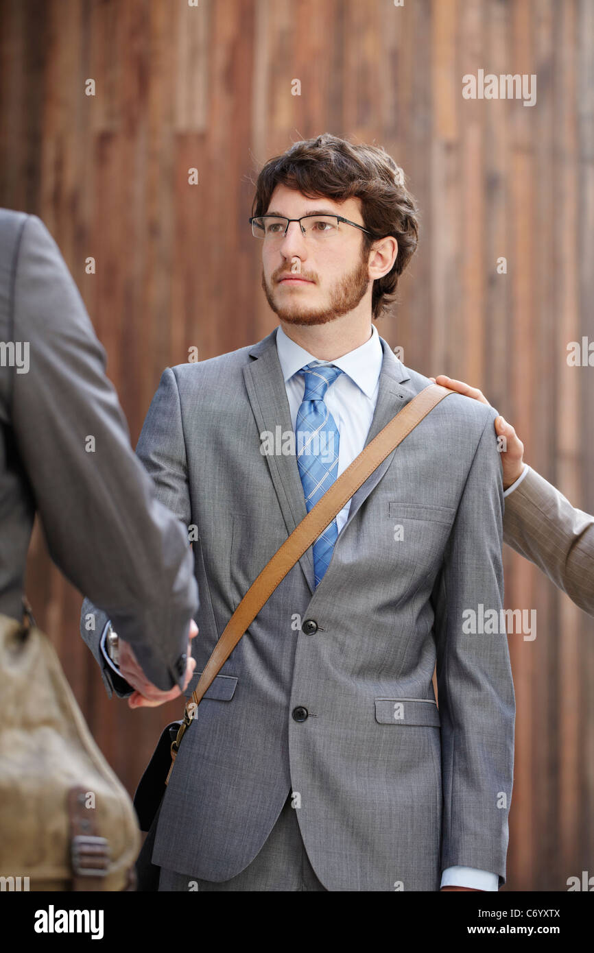 Businessmen shaking hands in courtyard Stock Photo