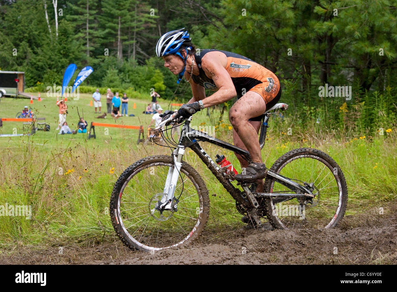 Female mountain bike racer pedals through muddy trail during off-road  triathlon race event Stock Photo - Alamy