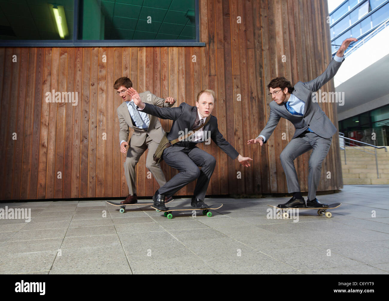 Businessmen riding skateboards Stock Photo