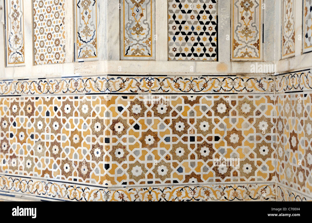 A wall decorated with  a repeating pattern of regular shapes made from semi precious stones inlaid in white marble. Stock Photo