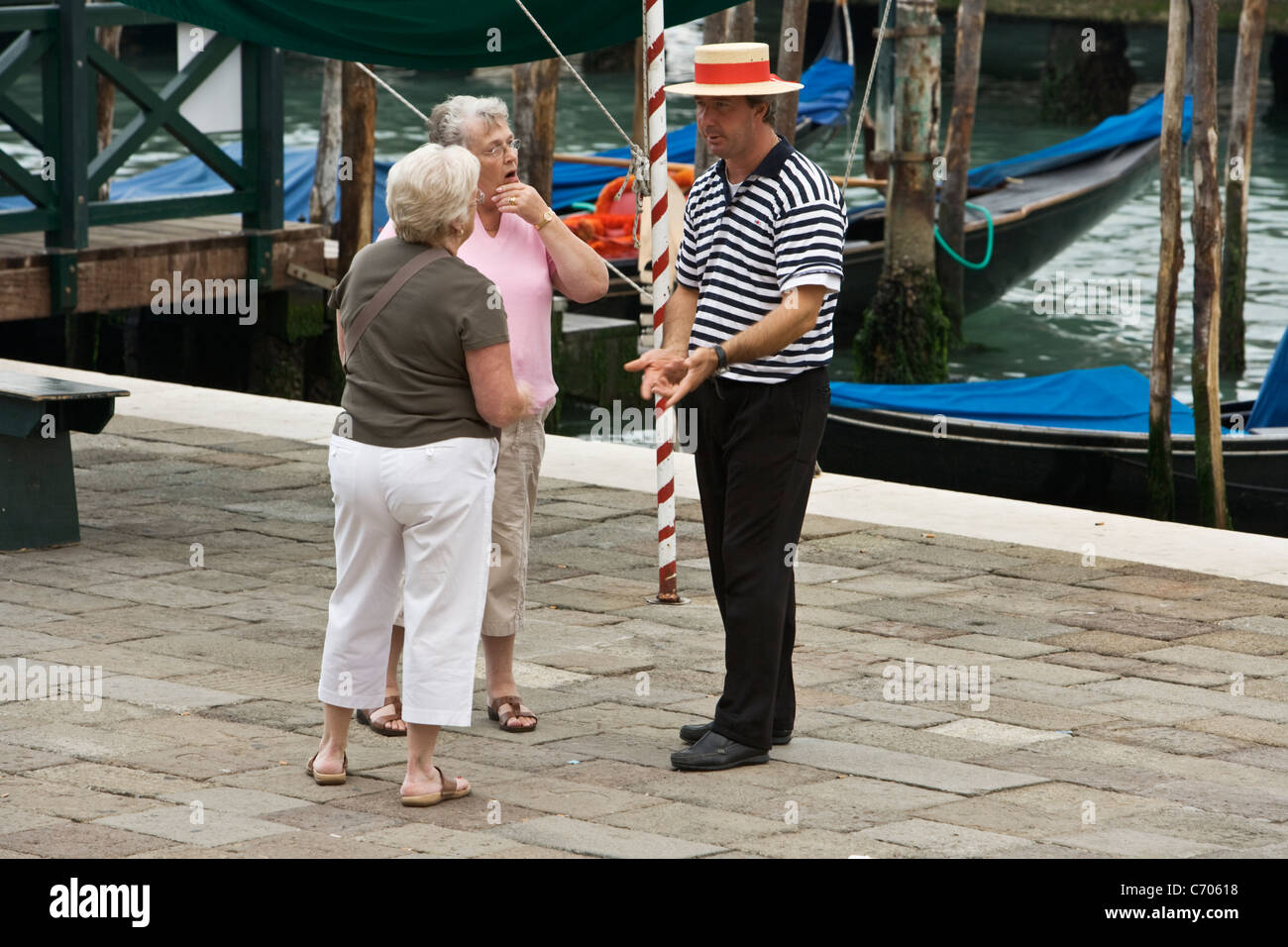 Tourists negotiate the price for a Gondola ride, Venice Stock Photo
