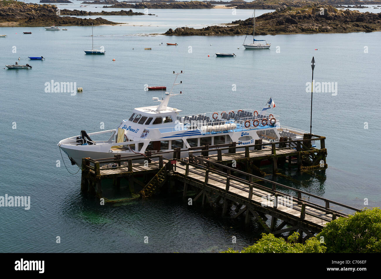 Tourist boat Jolie France II moored alongside jetty at high tide on Grande Ile in the Iles Chausey. Stock Photo
