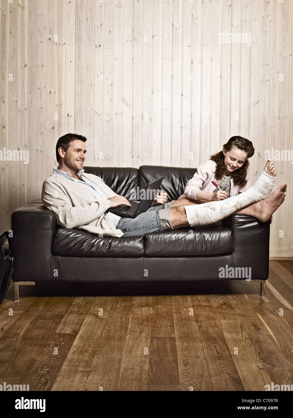 Girl writing on father's cast Stock Photo Alamy