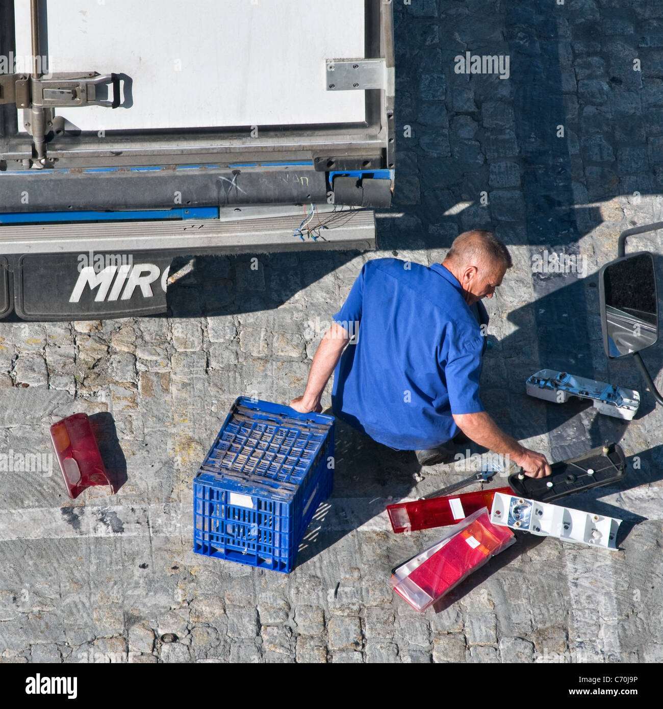 Man replacing the damaged tail lights on a lorry trailer. View from the rear behind. Close up Stock Photo
