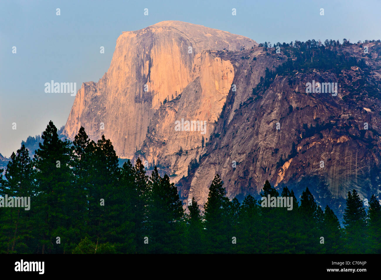 Half Dome, Yosemite National Park, USA, bathed in evening sunlight with blue smoke haze of forest fire. JMH5251 Stock Photo