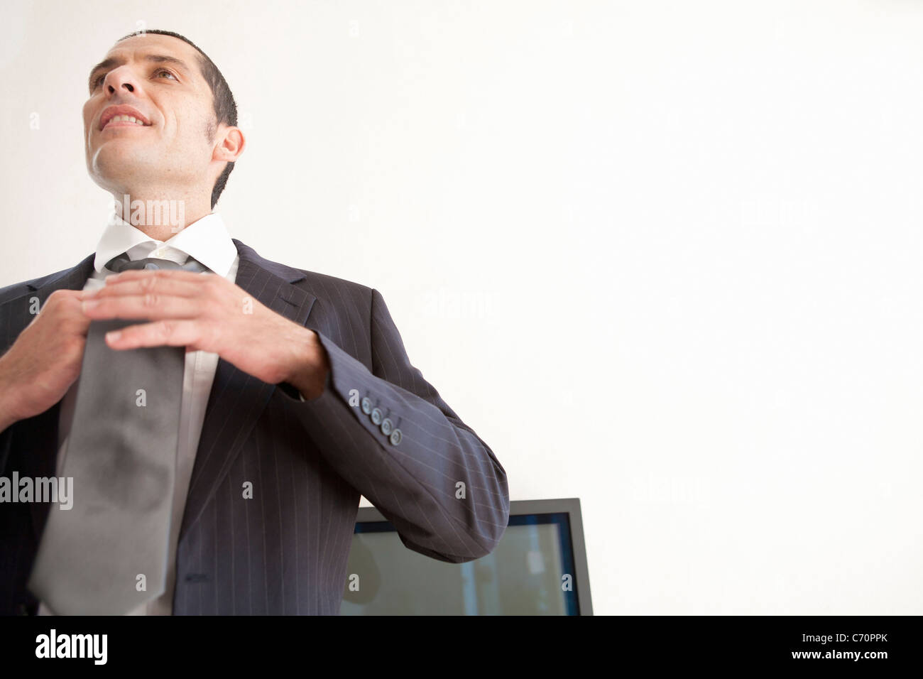 Businessman tying his tie in office Stock Photo - Alamy