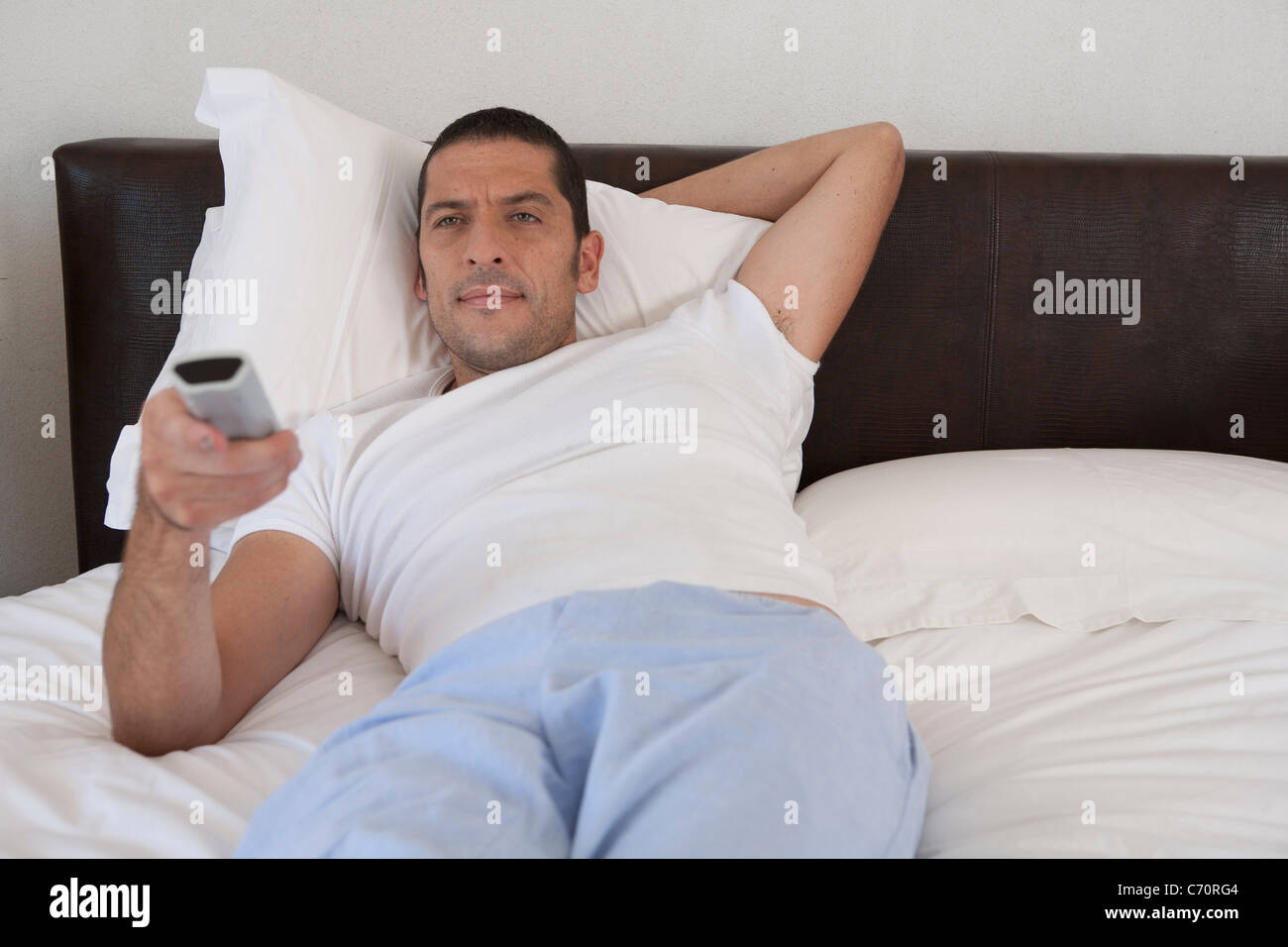 Man watching television in bed Stock Photo Alamy