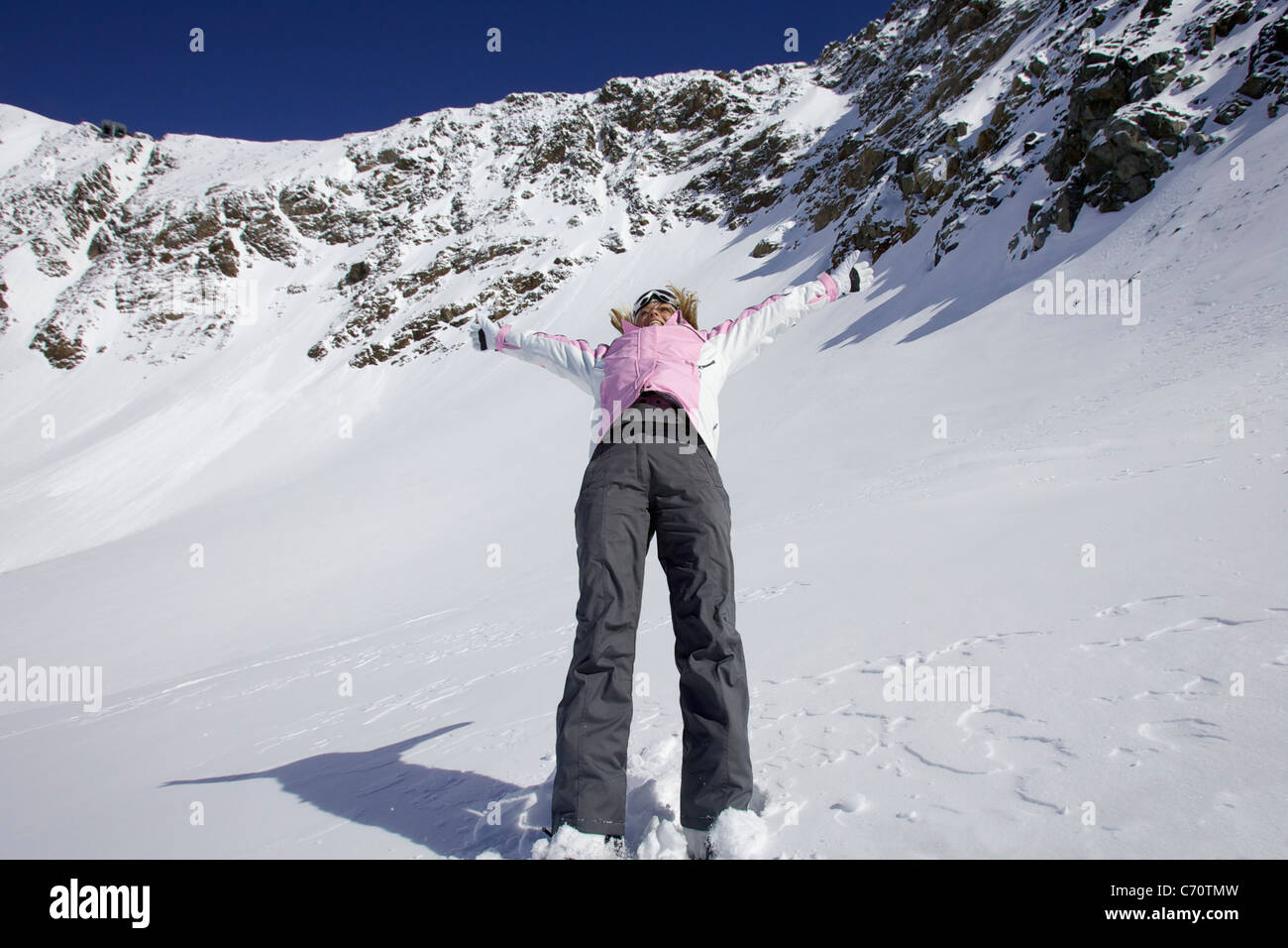 Woman skiing backwards down slope Stock Photo