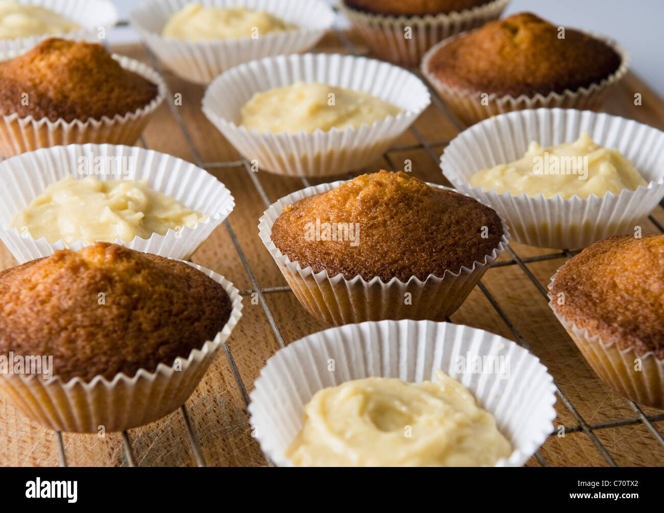 Baked cupcakes and batter on rack Stock Photo Alamy