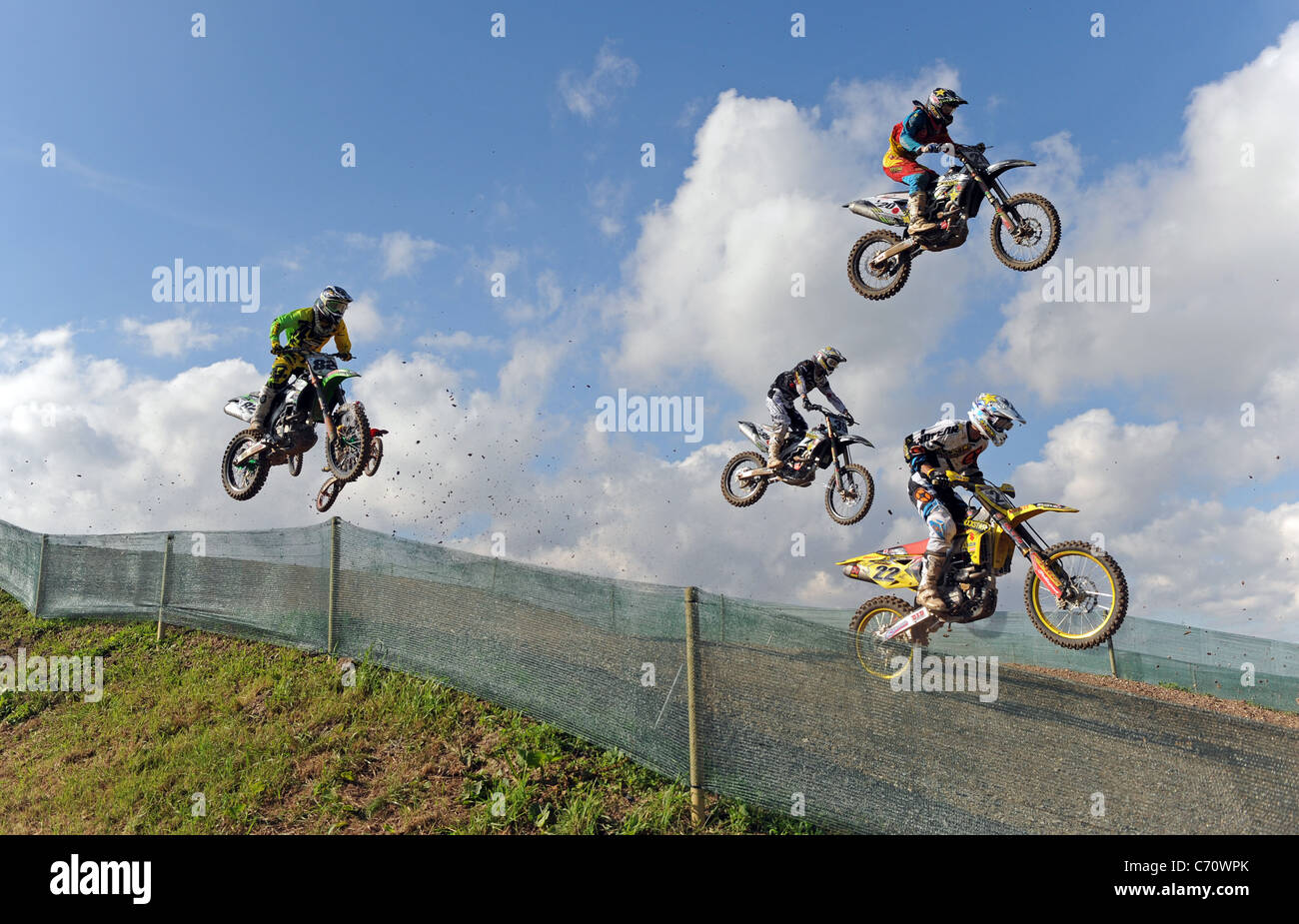 Motocross Racers jump through the air on MX Bikes Stock Photo Alamy