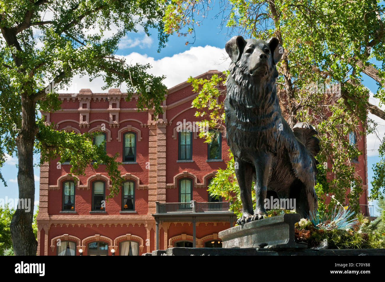 Bronze statue of dog 'Shep' by sculptor Bob Scriver, with the Grand Union Hotel behind, in Fort Benton, Montana. Stock Photo