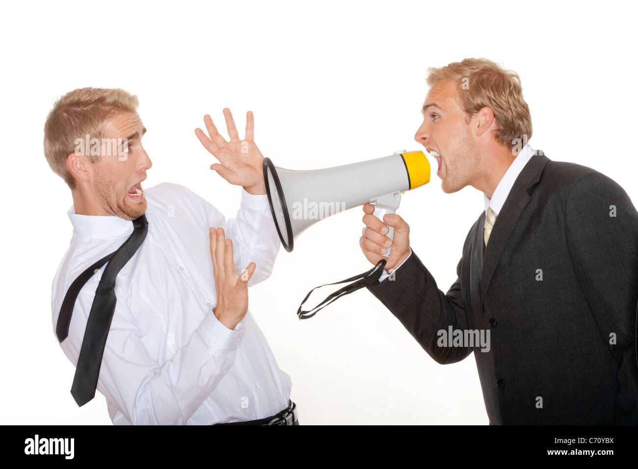 angry boss in suit yelling into a megaphone to scared employee - isolated on white Stock Photo