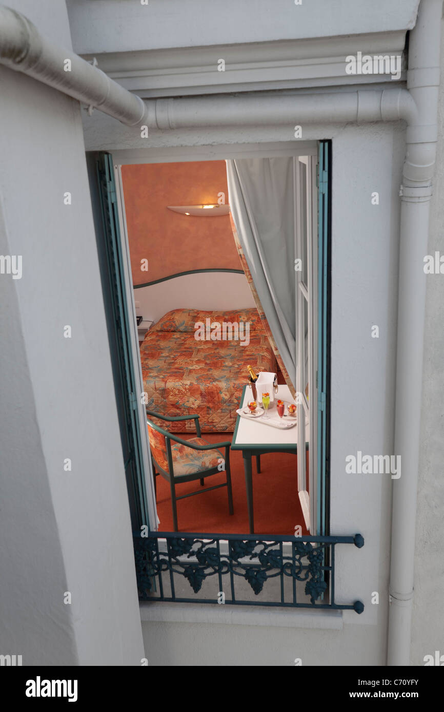 A view of a hotel room seen from an open window (France). Vue d'une chambre d'hôtel depuis la fenêtre ouverte (France). Stock Photo