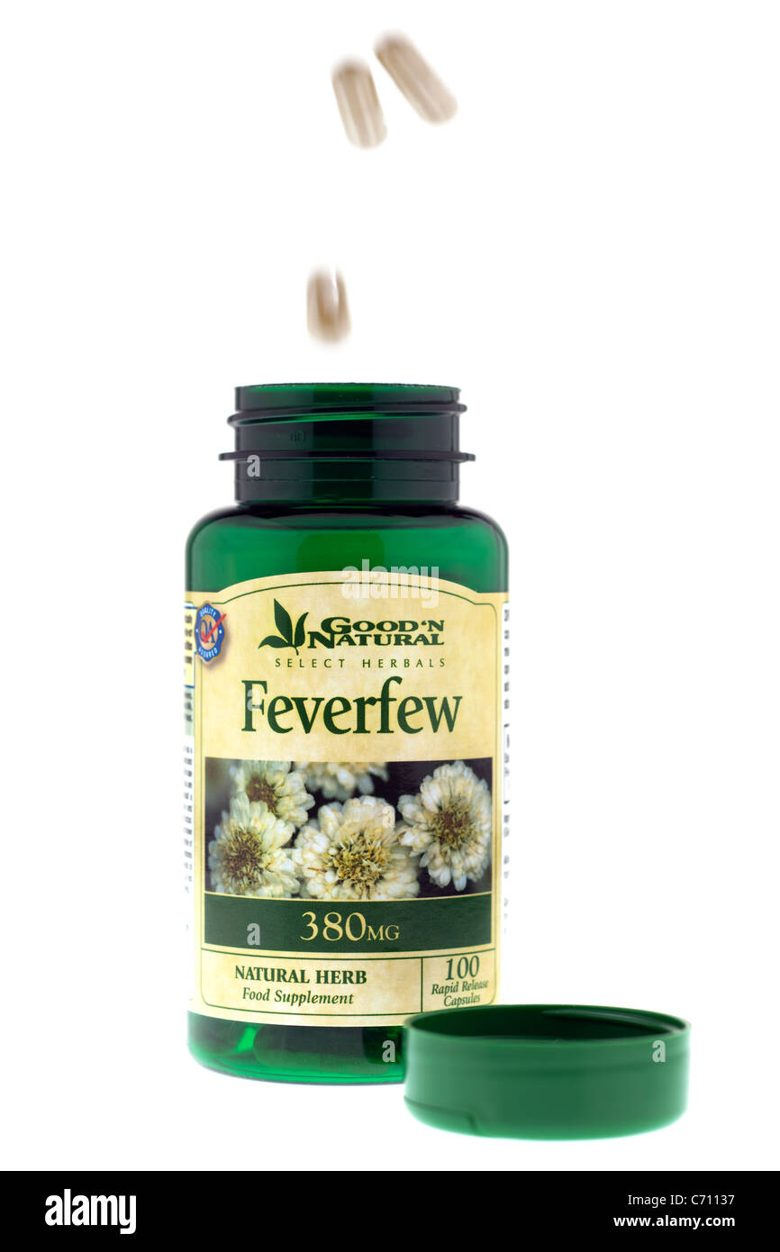 Food supplement capsules falling into a 380mg bottle of Good and Natural Feverfew Bottle Stock Photo