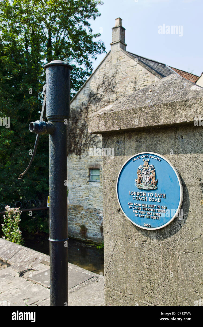 Blue plaque in Calne beside the A4 Bath Road at one time a coaching route showing old water pump used to suppress dust on the road Stock Photo