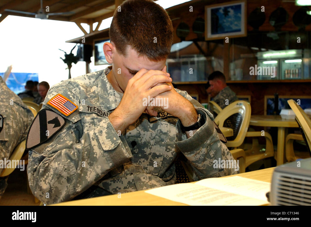 Lynnwood, Wash., native Spc. Alex Teesdale, a chaplains assistant for 4th Battalion, 227th Aviation Regiment, 1st Air Cavalry Brigade, 1st Cavalry Division, bows his head in prayer during a 9/11 prayer breakfast, Sept. 11 at Camp Taji, Iraq. Dozens of Soldiers gathered to pay tribute and remember those who lost their lives that somber day in America history and in the war on terror. (U.S. Army Photo by Spc. Nathan Hoskins, 1st ACB, 1st Cav. Div. Public Affairs) Stock Photo