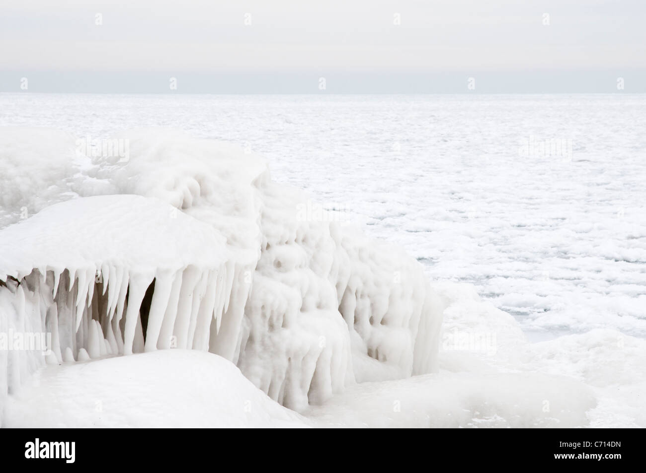 Layers of ice form over a breakwater on the shores of Lake Erie Stock ...