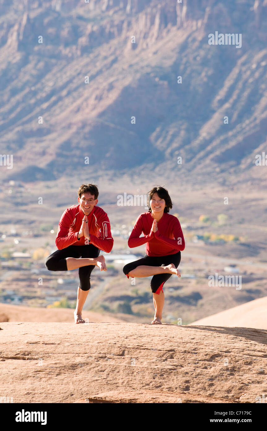 Man and woman striking a yoga pose in Moab, Utah Stock Photo Alamy