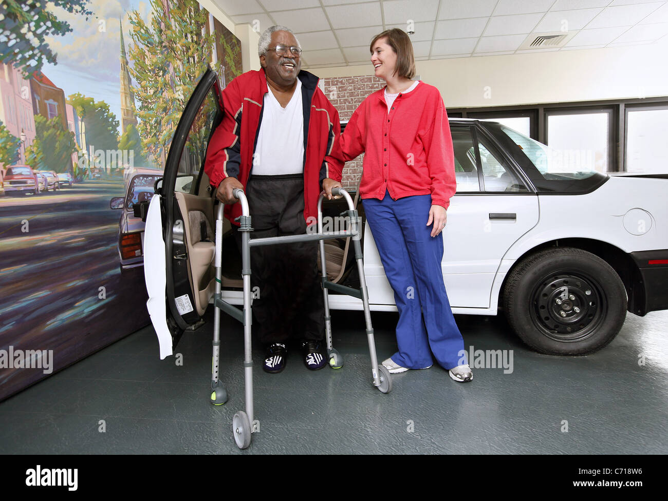 A physical therapist works with a patient on how to get in and out of a car. Stock Photo