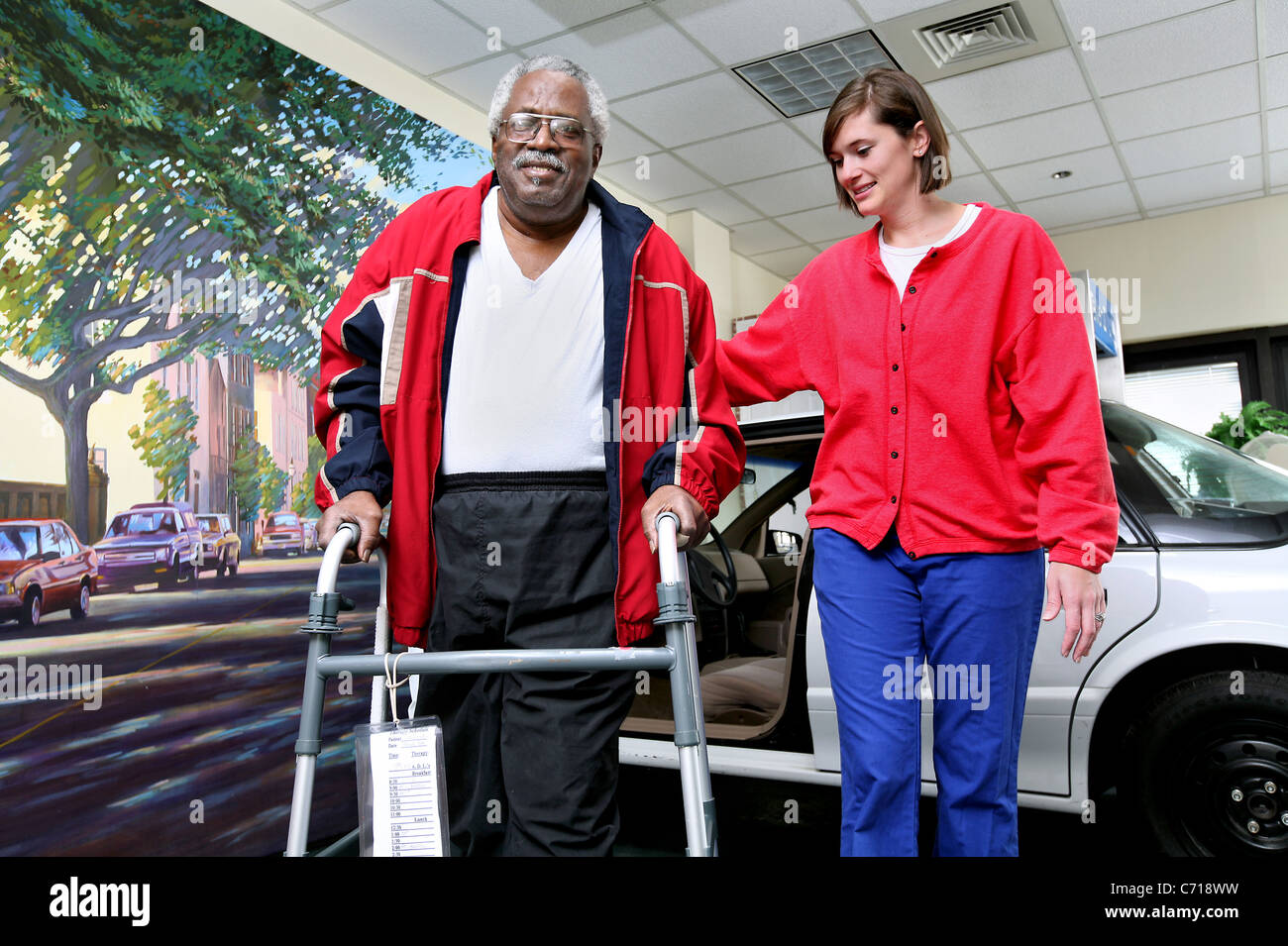 A physical therapist teaches a patient how to get in and out of a car. Stock Photo
