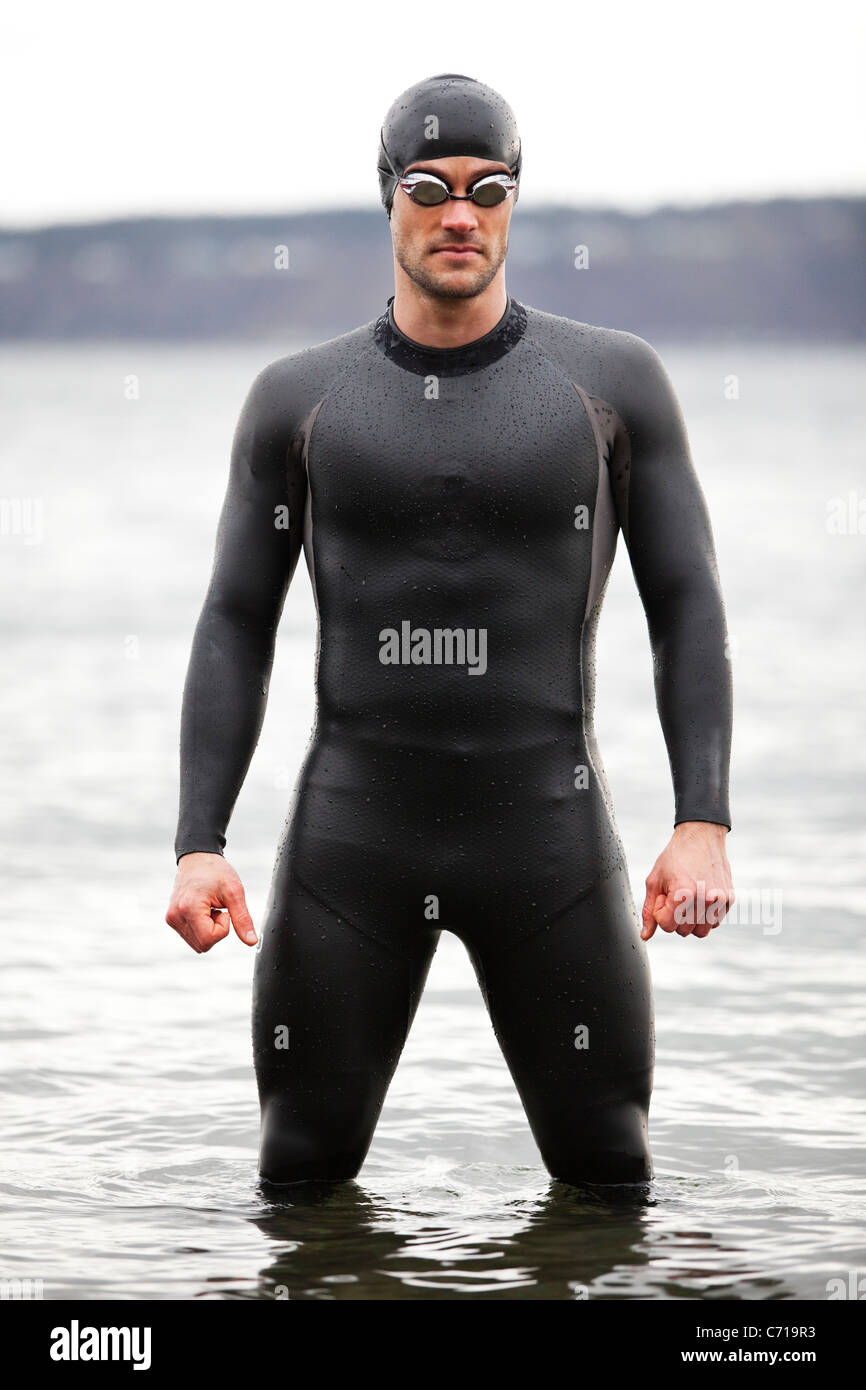 A triathlete stands ready for his swim. Stock Photo