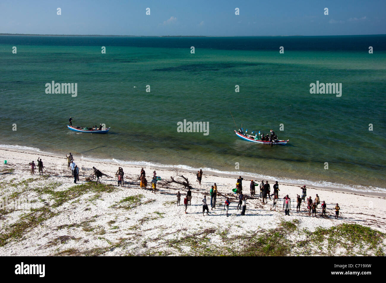 On a Mozambiquan beach a crowd of people wait for the catch of the day to come ashore. Stock Photo