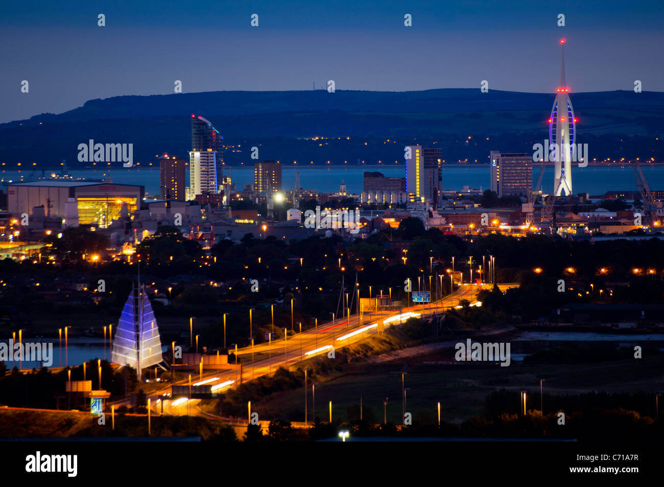 A panoramic view of Portsmouth city at night showing the Spinnaker Tower and the Isle of Wight in the distance. Stock Photo