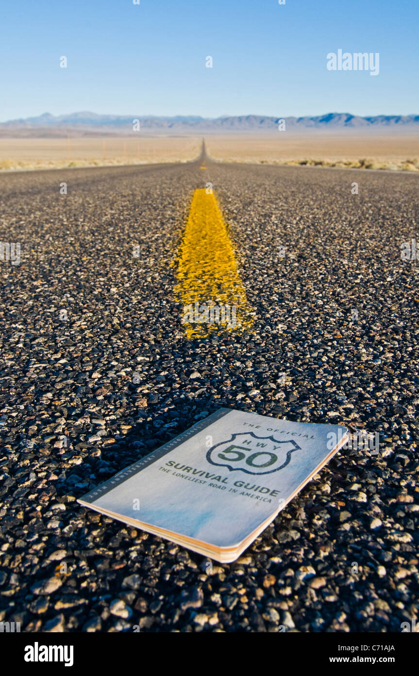 The Official Highway 50 Survival Guide sits on Highway 50, The Loneliest Road in America, in the Nevada desert. Stock Photo