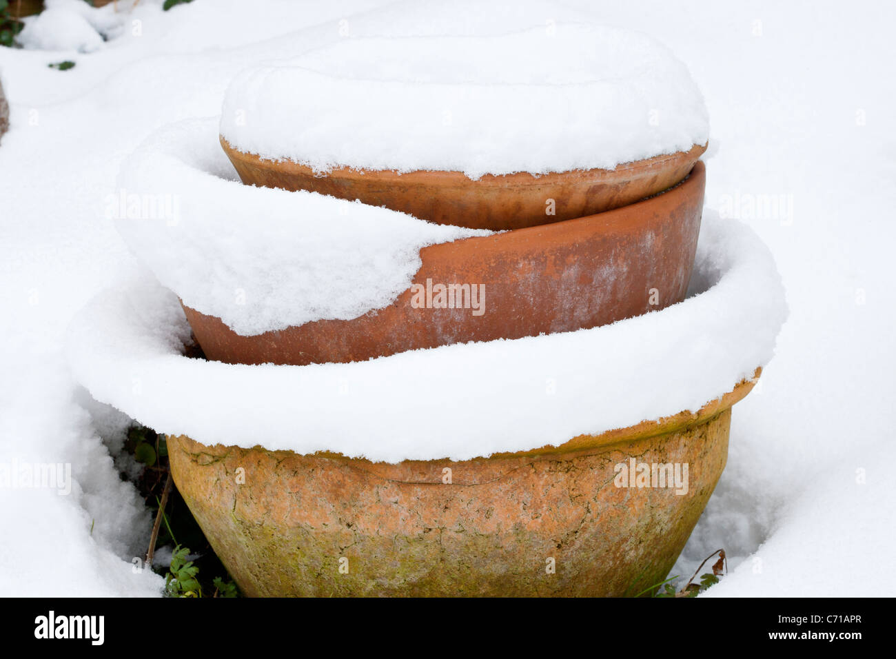 Old terracotta plant pots covered in snow, winter Stock Photo Alamy