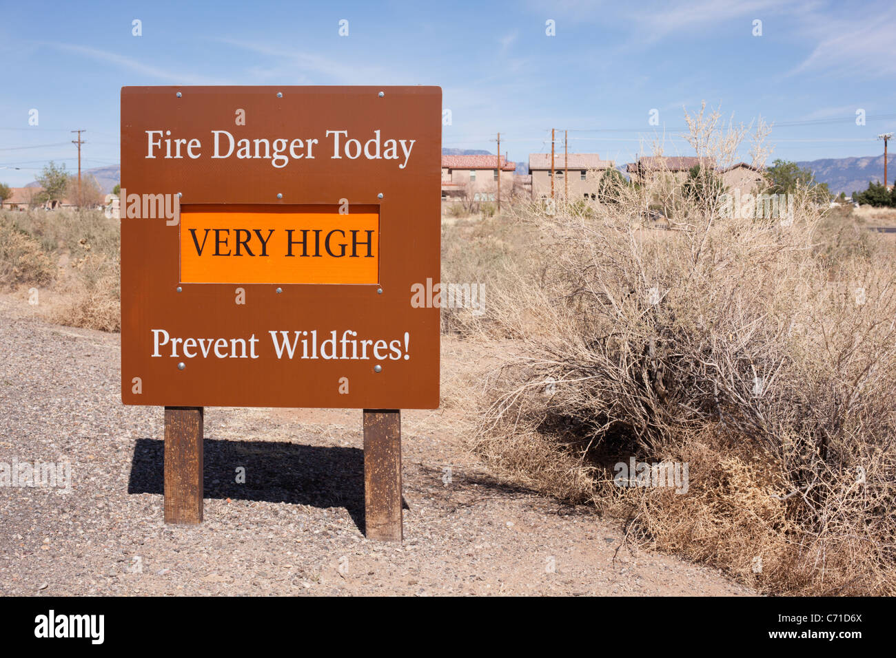 A fire danger sign and dry brush near an Albuquerque, New Mexico, neighborhood. Stock Photo