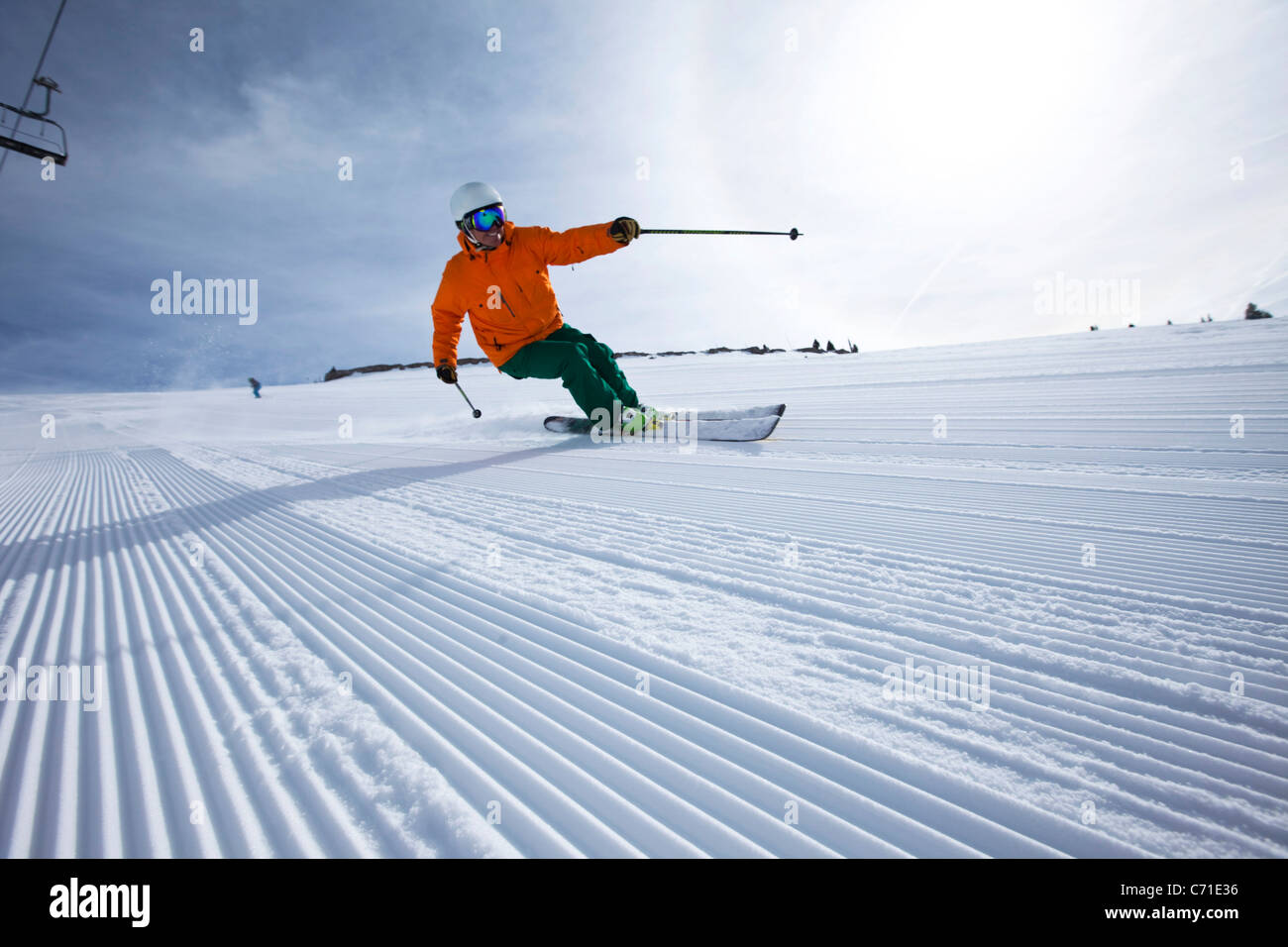 A male alpine skier smiles while skiing untracked groomers in Colorado. Stock Photo