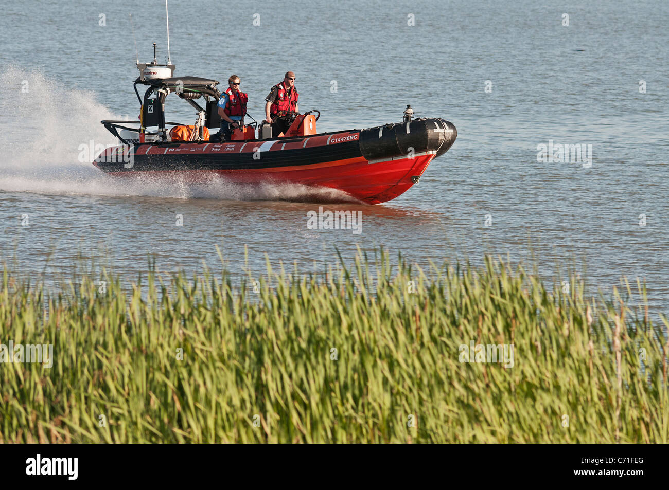 A Canadian Coast Guard Rigid Hull Inflatable Boat (RIB) and crew on patrol Fraser River, Richmond, B.C., Canada. Stock Photo