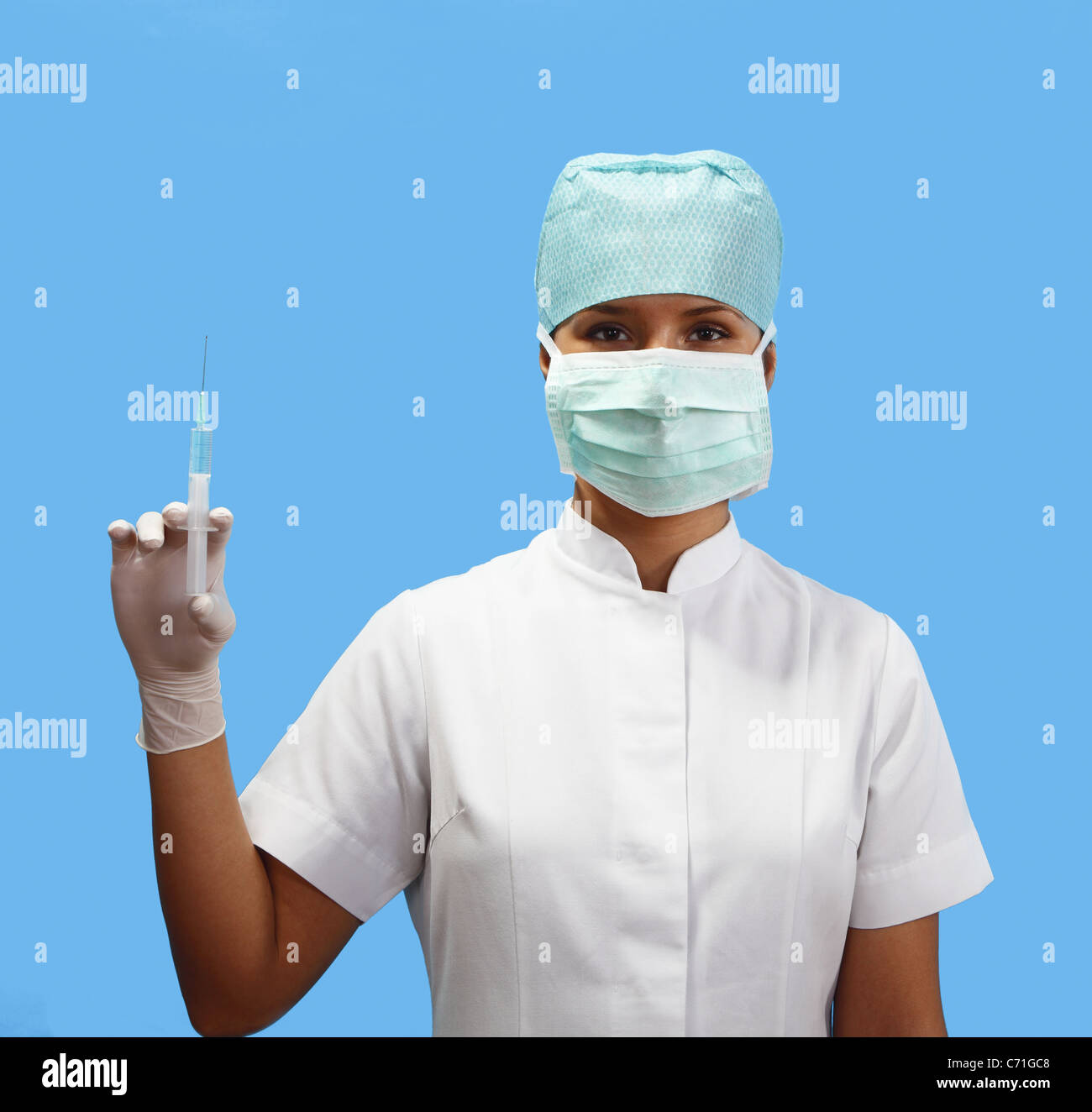Female nurse holding a syringe isolated against a blue background Stock Photo Alamy