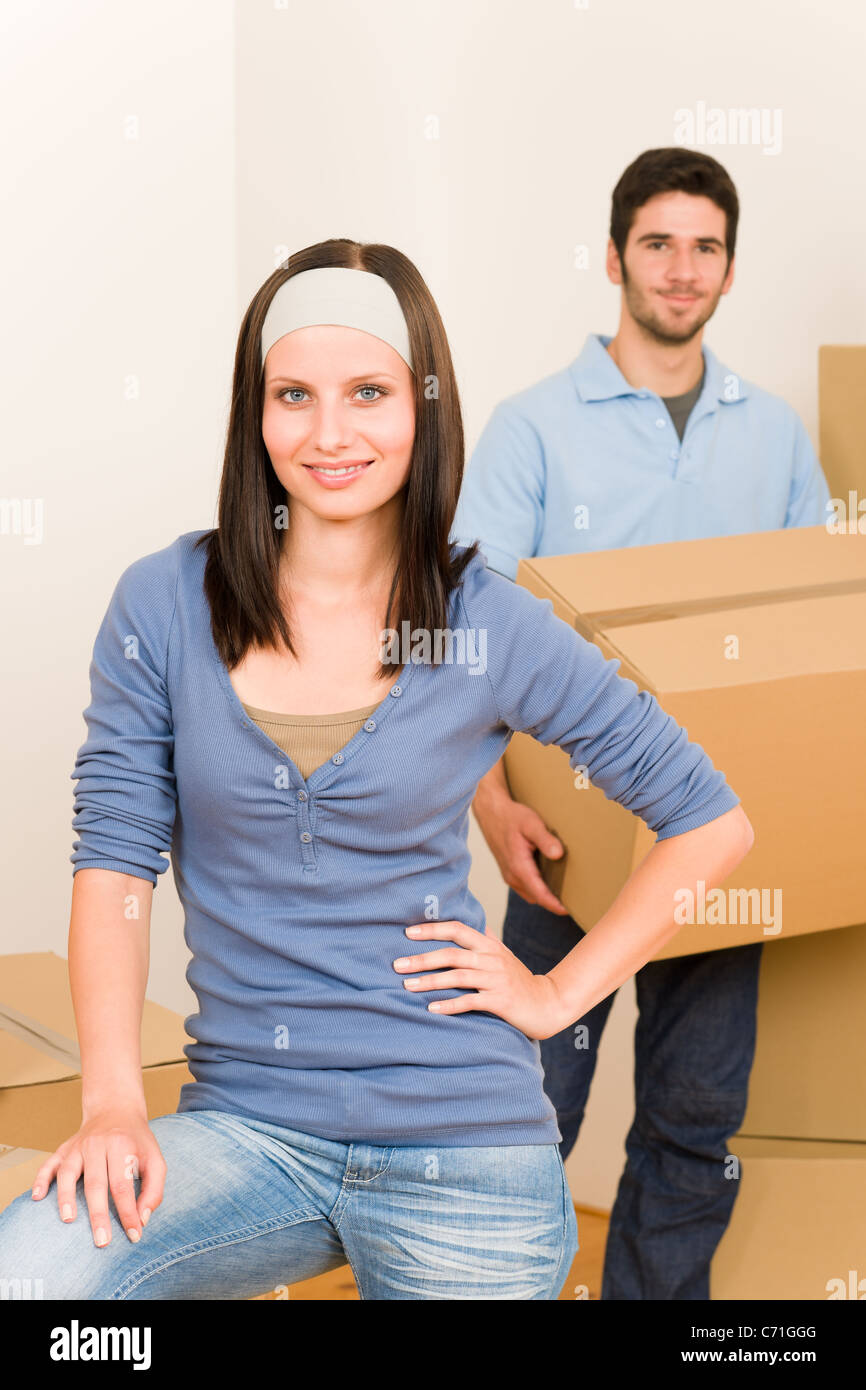 Happy young couple moving into new home carrying cardboard boxes Stock ...