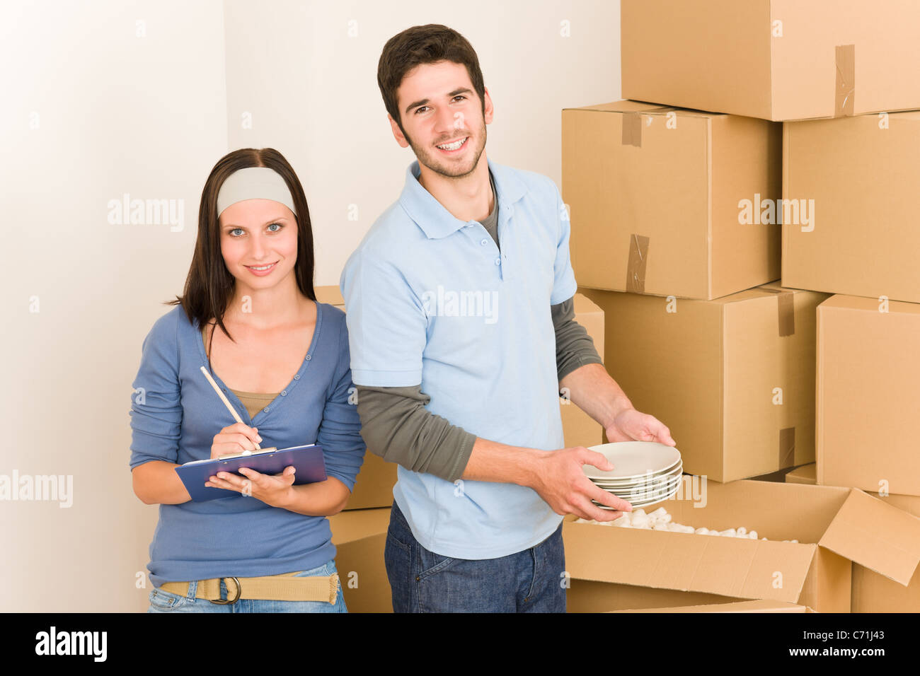 Moving new home young happy couple unpacking cardboard boxes together ...