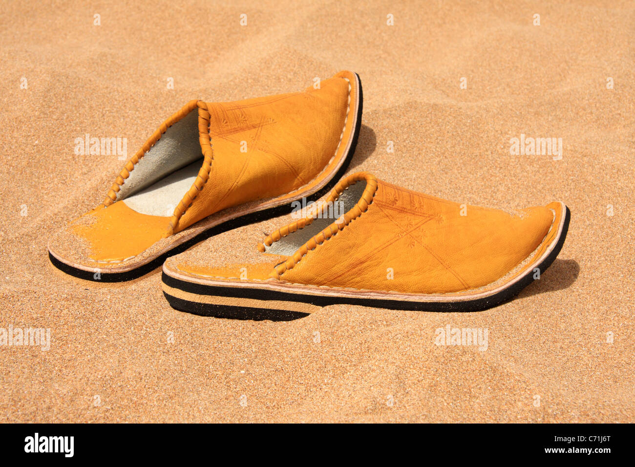 Traditional Moroccan slippers shoes (babouches) on a Moroccan beach. Stock Photo