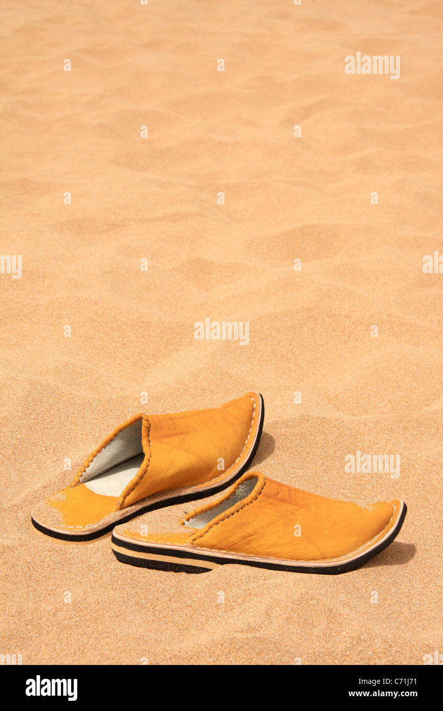 Traditional Moroccan slipper-shoes (babouches) in the sand on a  Moroccan beach with copy space, Morocco, North Africa Stock Photo