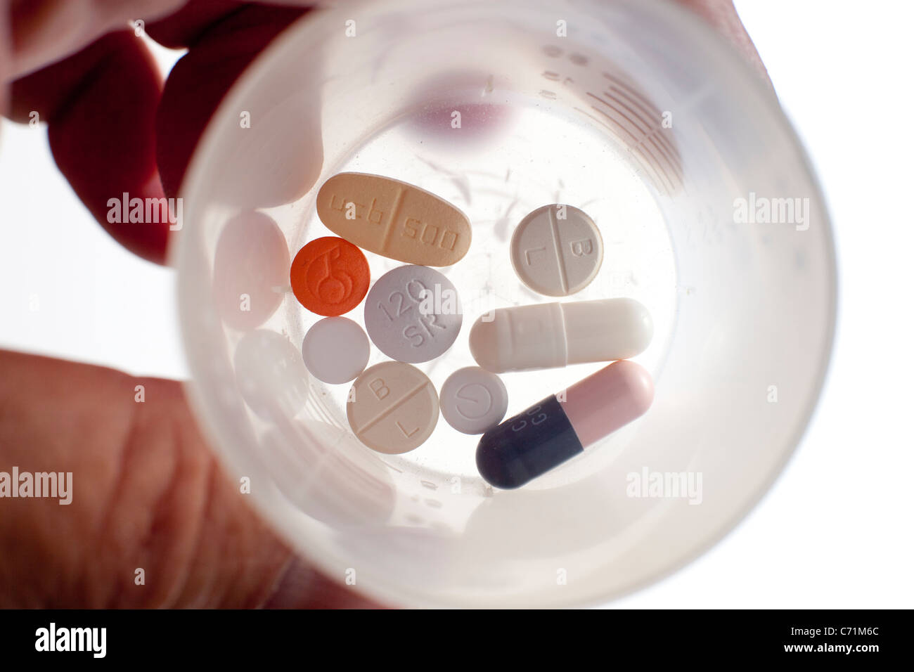 A dose of medication tablets in a plastic beaker Stock Photo