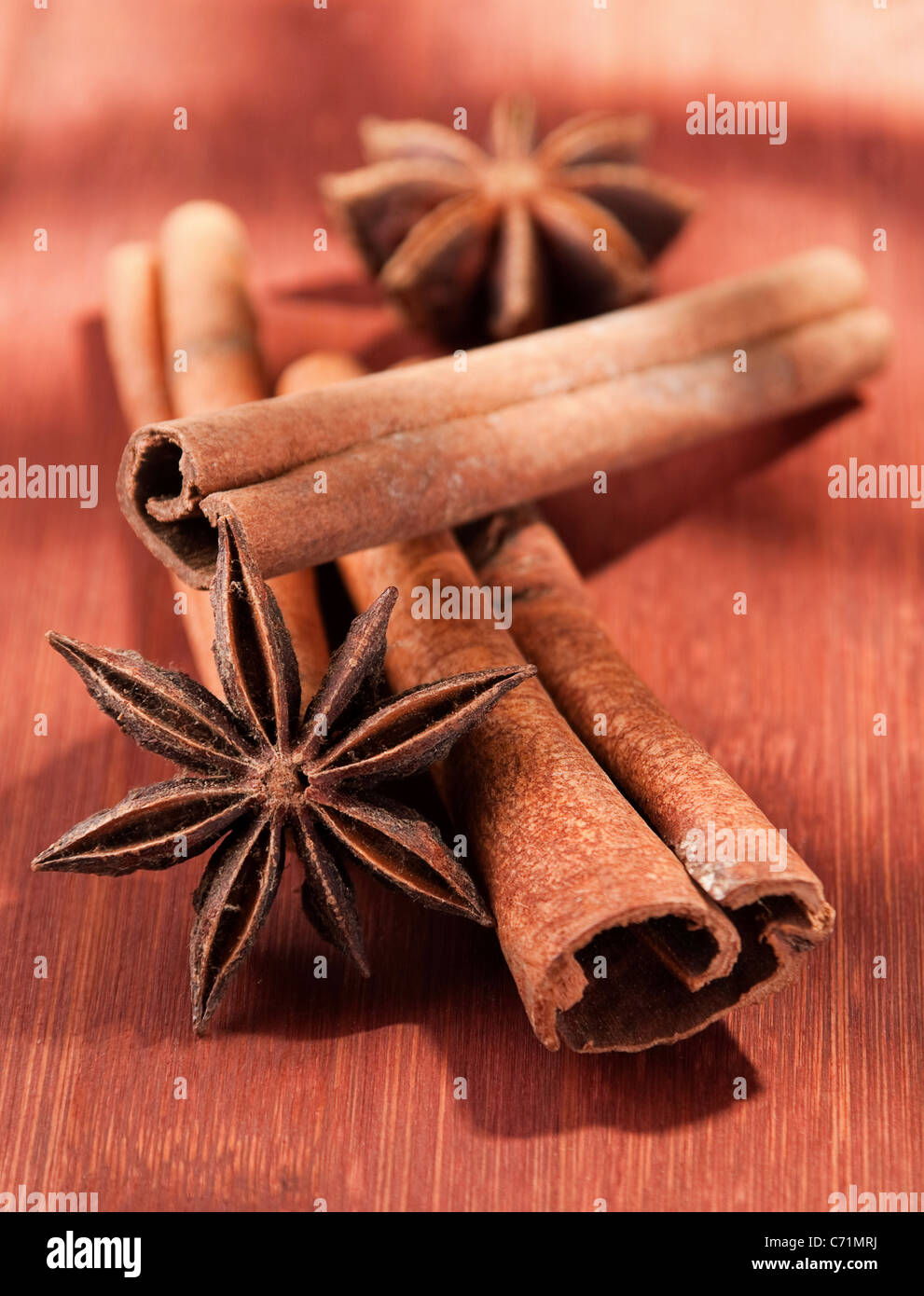 Stick of cinnamon with anise closeup on brown board Stock Photo