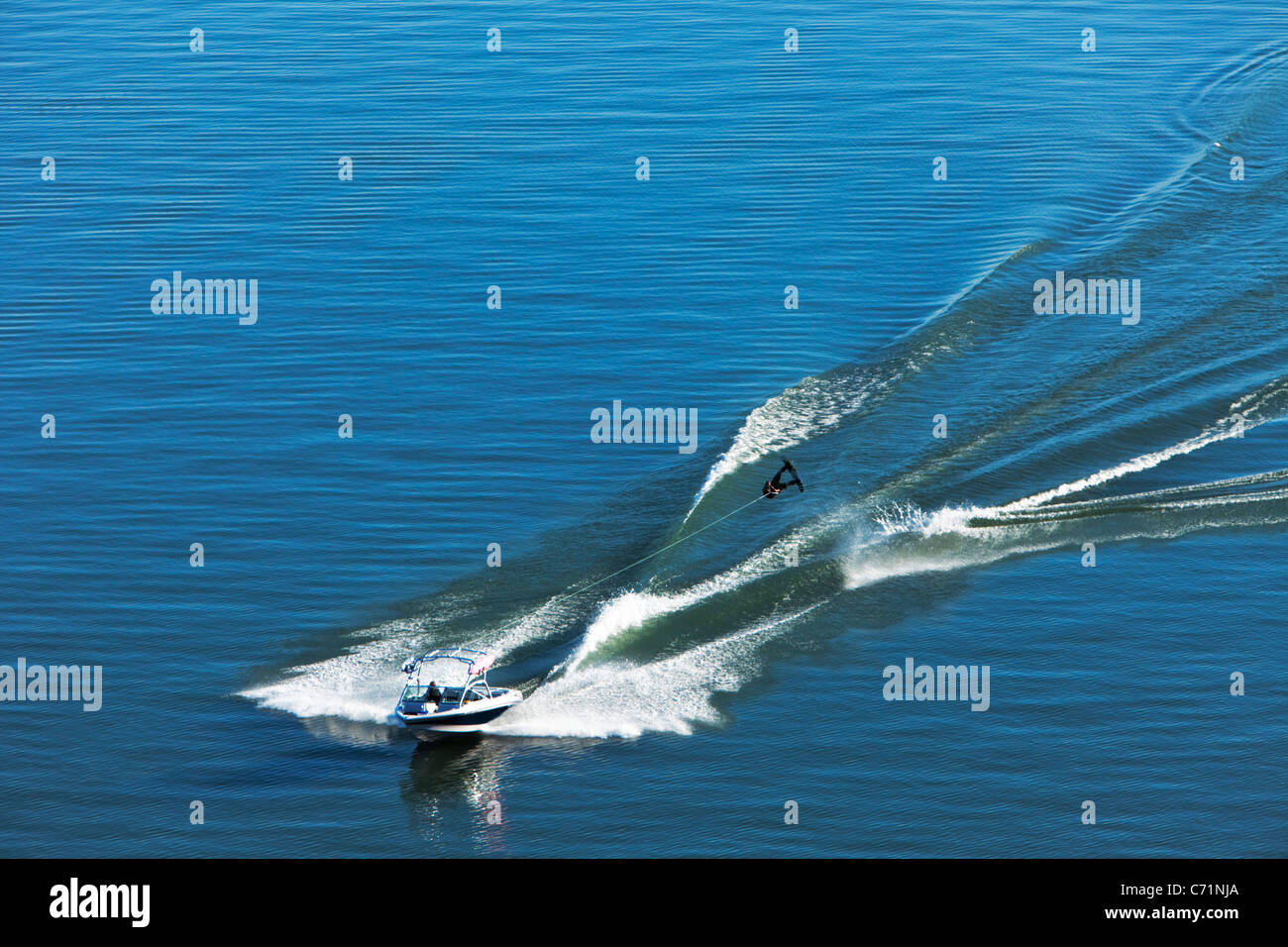 A athletic wakeboarder jumps the wake going huge on a calm day in Idaho. Stock Photo