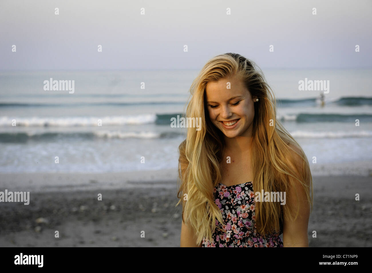 A young woman smiles at the beach Stock Photo - Alamy
